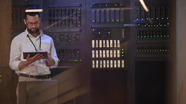 It specialist managing server racks with a tablet in a data center for cloud computing and network administration