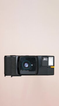 Vertical Stop Motion of Vintage Analog Camera Disassembling and Assembling, Knolling Style on Beige Background