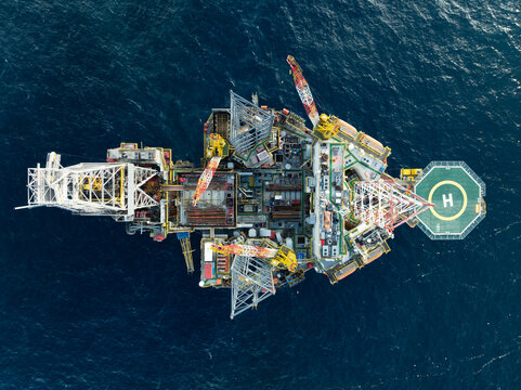 Aerial view from a drone of big jack up offshore drilling oil rig, production platform in the ocean during day time - Oil and Gas Industry