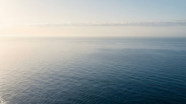 Wide ocean horizon with light cloud cover