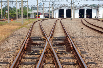 Obraz premium Railway Track Switch and Junction System at a Train Depot and Maintenance Yard with Hangar Buildings