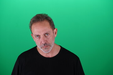 Fototapeta premium Real people. Man at his 50s, Close up shot, isolated on green screen in various poses and facial expressions. Studio capture with clean chroma key background, ideal for compositing