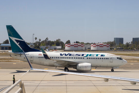 Santa Ana, CA, USA - May 6, 2022: A Boeing 737-700 operated by WestJet, a Canadian airline based in Calgary, Alberta, is seen taxiing on the tarmac at John Wayne Airport in Santa Ana, California.