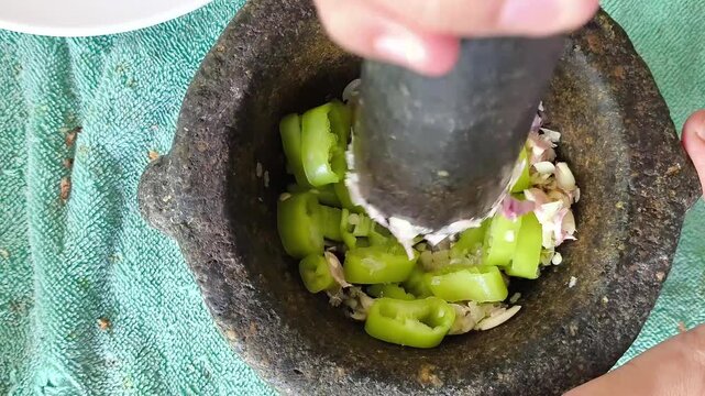 Pounding chili and herbs in mortar,  cooking Thai food.