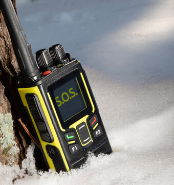 SOS signal showing on a walkie-talkie in the snow