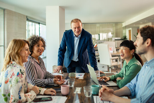 Diverse business team meeting with senior leader in modern office