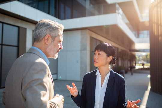 Two business colleagues discussing outside modern office