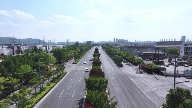 Urban arterial road with green medians and vehicles in motion under clear sky