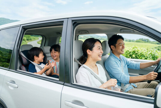 車でドライブ旅行を楽しむ笑顔の日本人家族 Generative AI