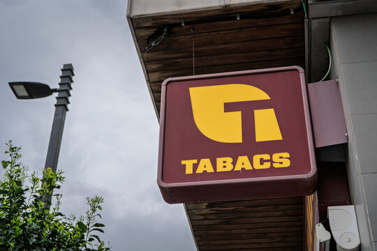 BARCELONA, SPAIN - FEBRUARY 28, 2026: A Tabacs sign marks a Spanish tobacconist in Barcelona, Catalonia, with the yellow and burgundy tobacco symbol mounted on a shopfront, called estanco.