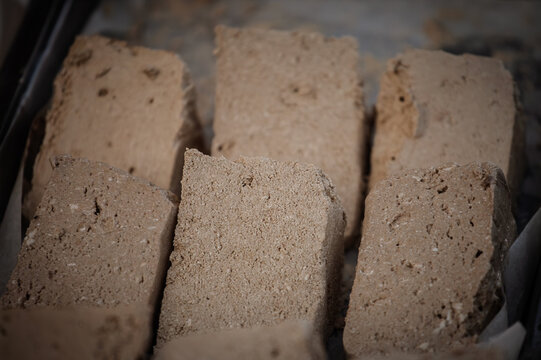 Selective blur on blocks of alva, or halva, displayed for sale in a market, showing the dense texture of a traditional sweet confection made with sesame or similar ingredients in the balkans.