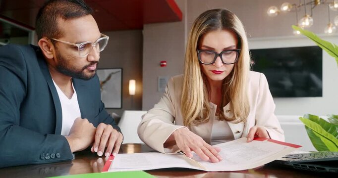 Business professionals reviewing documents at modern office table