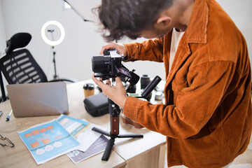 Fototapeta premium Videographer Setting up Mirrorless Camera on Gimbal Stabilizer in Modern Home Studio Office