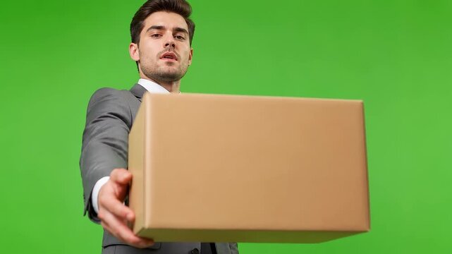 Determined Businessman in Suit Holds Out Cardboard Box for Delivery or Presentation, Isolated