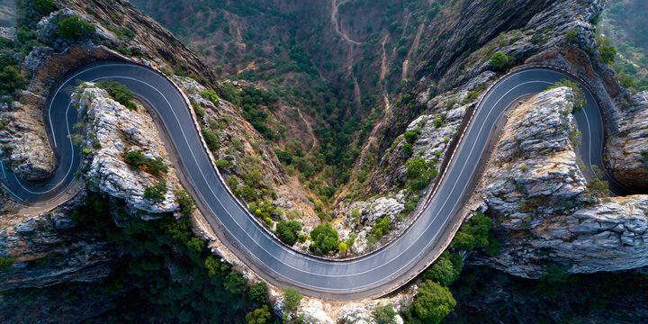 Curved Mountain Pass Road with Rocky Terrain and Trees