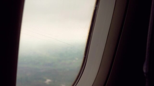 Close up view of raindrops moving on the window of airplane, plane flying in rainy day, 4k slow motion footage travel concept b roll shot.