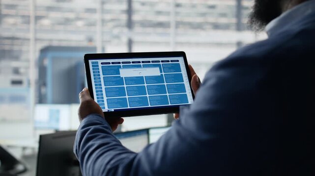 Close up of engineer examining microchip circuit layouts on tablet in factory office, r&D workspace using device app to improve semiconductor manufacturing for semiconductor research.