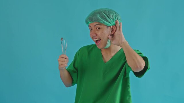 Curious healthcare professional cupping his ear to hear something with dental gear.
