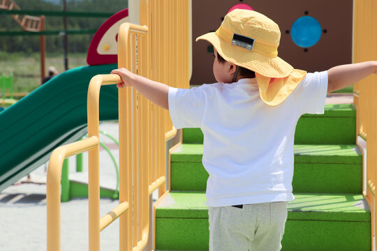 公園の遊具やアスレチックで遊ぶ幼児の姿。挑戦する気持ちや好奇心、運動能力の発達をイメージした写真素材。