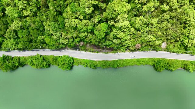 Top down view of lake side road and green mountain in japan, Beautiful landscape and sun light reflection in water.