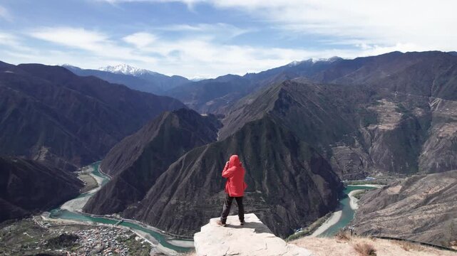 Drone panning view of unrecognition man in red coat on Muma mountains in Jinchuan country, Aba Tibetan and Qiang Autonomous Prefecture, Sichuan, China. 4k real time footage, travel concept.