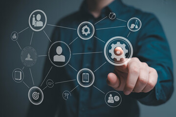 Fototapeta premium Businessman touching a virtual screen with a network of interconnected business and communication icons.