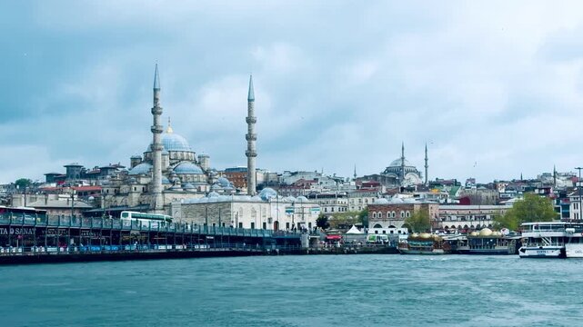 Scenic view of the historic New Mosque and Galata bridge look from Bosphorus sea water near Istanbul Golden Horn bay. Traditional passenger ferry transport and tourism cruise destination in city.