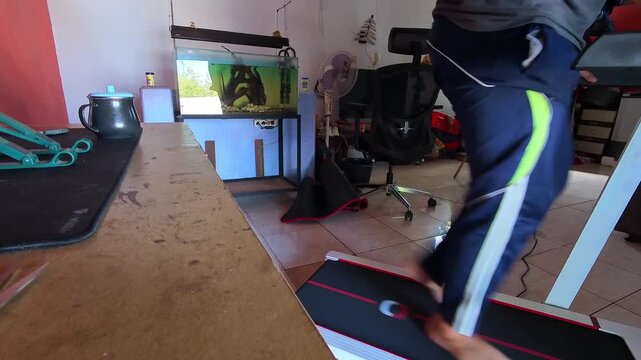 Timelapse Video of Person running barefoot on treadmill indoors. Room features aquarium, desk, and office chair. Settings suggest home workout or fitness routine. 4K Time Lapse