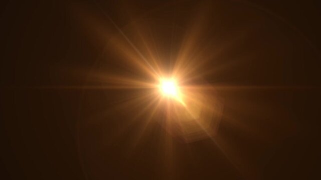 Abstract bright light burst with optical lens flare,Bright explosion of fire and light in a starry night sky with a optical lens flare.