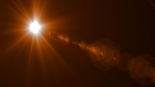 Abstract bright light burst with optical lens flare,Bright explosion of fire and light in a starry night sky with a optical lens flare.
