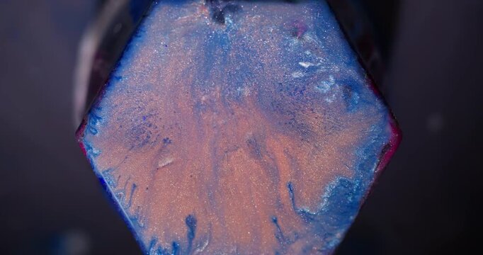 Shiny splatter. Paint spill hexagon. Defocused blue orange pink color geometric gem texture glitter particles on abstract background.