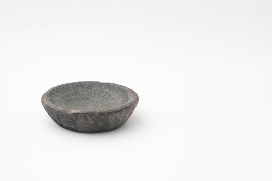 Authentic Indonesian stone mortar bowl or cobek isolated on a clean white background. Used for grinding traditional spices and making sambal.
