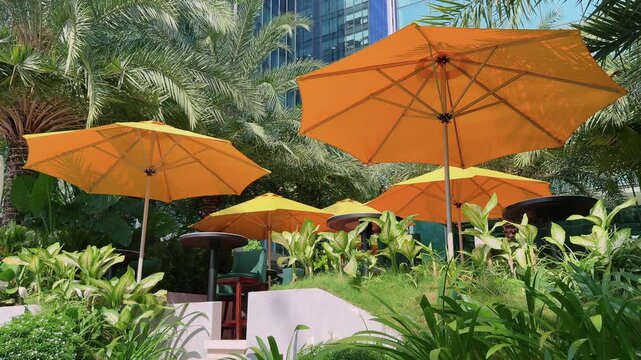 Yellow Parasols in Tropical Hotel Garden Terrace with City Background