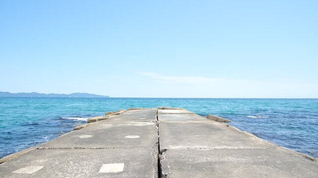 Concrete Jetty Extending into Blue Sea with Constant Waves