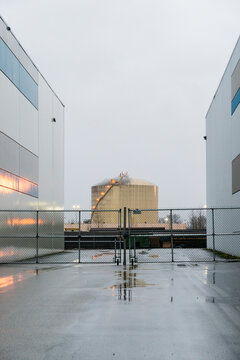 Canada, BC, Delta.  Liquified Natural Gas storage tank viewed between two warehouse buildings in the Tilbury Industrial Park.  
