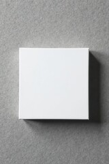 Fototapeta premium Blank white square card, gift box on grey concrete Perfect for branding , packaging, template