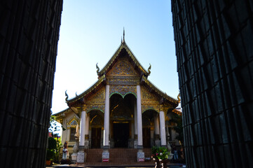 Fototapeta premium Chapel and Golden Pagoda, Lanna Architecture, Symbols of Buddhism, South East Asia at Wat Chomphu, Chiangmai, Northern Thailand