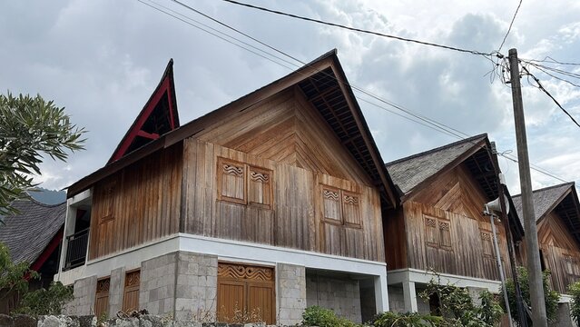 Traditional Batak Toba traditional house (Rumah Bolon) with its iconic boat-shaped roof and intricate Gorga carvings in Samosir Island, Lake Toba, Indonesia