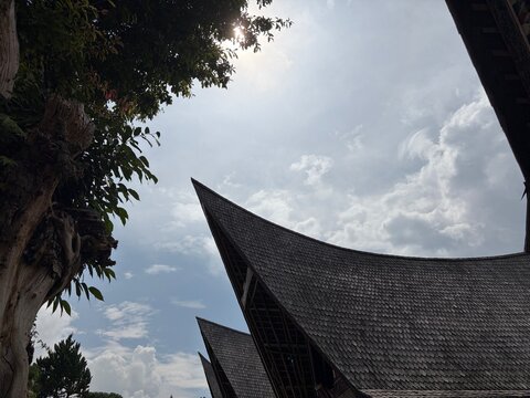 Traditional Batak Toba traditional house (Rumah Bolon) with its iconic boat-shaped roof and intricate Gorga carvings in Samosir Island, Lake Toba, Indonesia