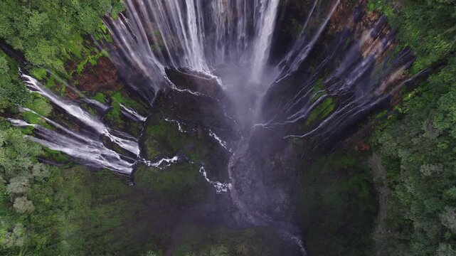 Aerial view of majestic Tumpak Sewu waterfall in East Java Indonesia surrounded by lush tropical rainforest.