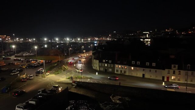 Salerie Corner and Glategny Esplanade St Peter Port Guernsey.Rising night time drone footage with traffic passing by and twinkling views across to the harbour with vibrant atmosphere