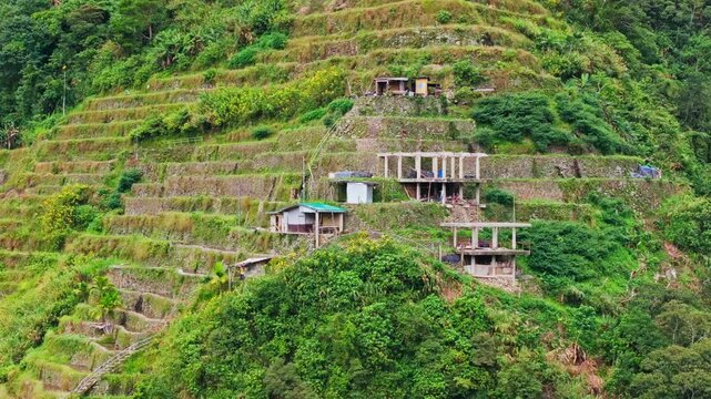 Drone glides left unveiling Batad terraces, mountain heritage and rural life