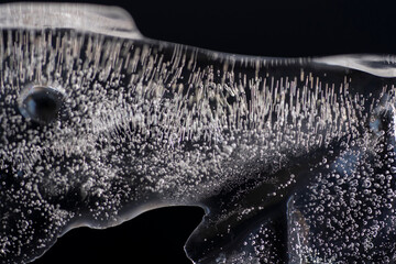 acercamiento a bloque de hielo con burbujas dando formas abstractas con fondo negro © AnaPliego