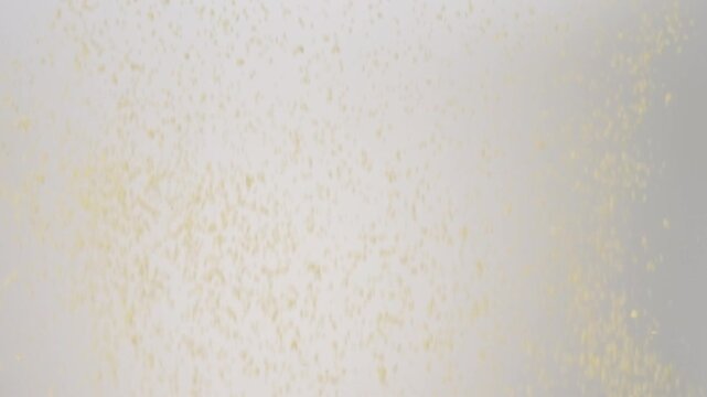 Dry uncooked Couscous raining down on a white backdrop in slow motion close up macro.
