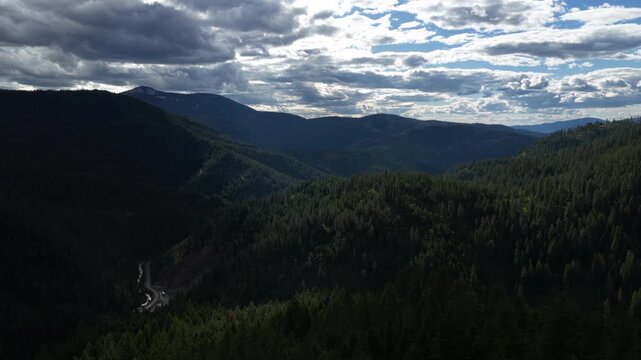 Wide Aerial of forested mountains in Shoshone County Idaho with stormy sky in spring near Kellogg