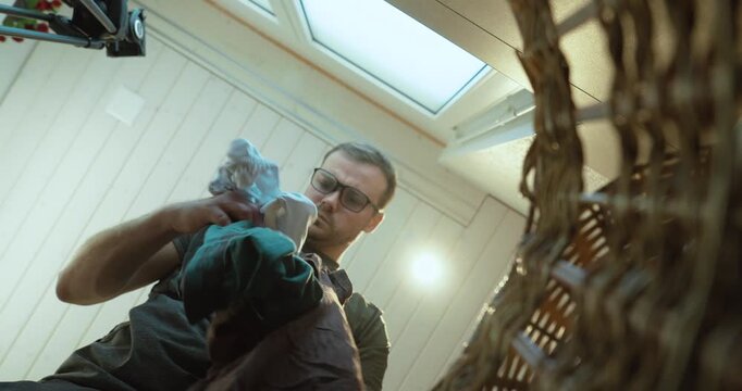 POV stock video filmed from inside a laundry basket showing a man searching through dirty laundry and looking for clothing items. Suitable for household chores, laundry routines, home organization