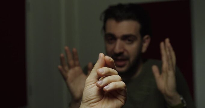 Person making a hand gesture indicating a demand for money during a tense interpersonal confrontation.