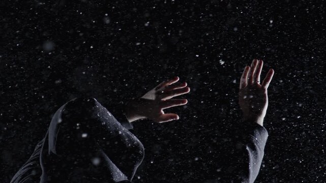 Thriller scene shows hooded figure. Thriller man moves through storm. Dark thriller concept builds suspense. Snowy thriller footage feels dramatic.