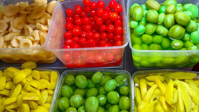 Various Colors of Candied Fruits and Pickled Vegetables in Plastic Containers at Asian Markets
