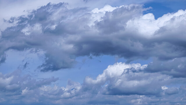 Dramatic dark storm clouds filling a bright blue sky, creating a moody atmospheric background